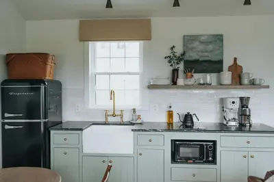 a kitchen with a black refrigerator and a sink at Luxury Cabin getaway with hot tub and stunning views in Strasburg