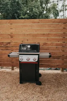 a barbecue grill sitting in front of a wooden bench at Luxury Cabin getaway with hot tub and stunning views in Strasburg