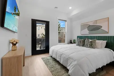 a white bedroom with a large bed and a window at Luxury Duplex in Hoboken 15Min to NYC, Fire Pit in Jersey City