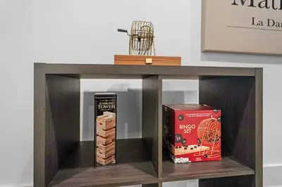 a wooden shelf with a box and a book on it at Luxury Duplex in Hoboken 15Min to NYC, Fire Pit in Jersey City