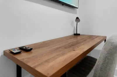 a wooden table with two remote controls on it at Luxury Duplex in Hoboken 15Min to NYC, Fire Pit in Jersey City