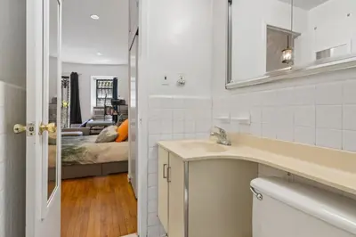 a bathroom with a sink and a bedroom at Stylish Studio in Central Park Best Location Ever in New York