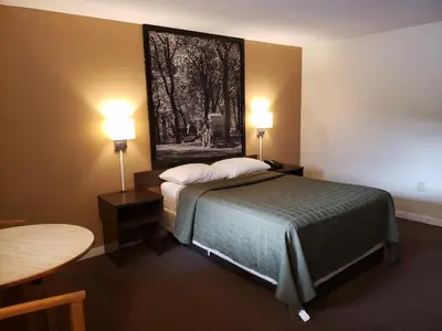 a hotel room with a bed and a picture on the wall at Mansfield Inn in Mansfield