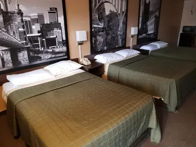 a hotel room with three beds in a room at Mansfield Inn in Mansfield