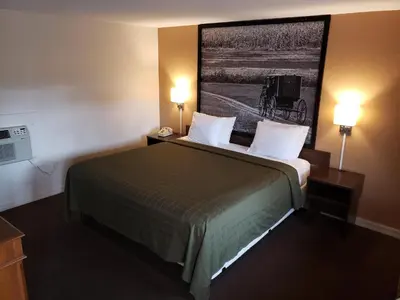 a hotel room with a large bed with two lamps at Mansfield Inn in Mansfield