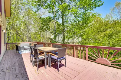 a wooden deck with a table and chairs on it at Poconos Family Home with Lake Access and Game Room in Tobyhanna