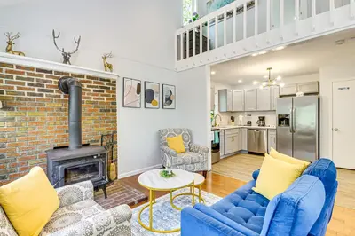a living room with blue furniture and a brick fireplace at Poconos Family Home with Lake Access and Game Room in Tobyhanna