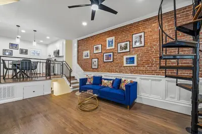 a living room with a blue couch and a brick wall at Free Parking -NEW 3BR-2Bath, 5 Beds, 10 Min to NYC, Sleeps 7 in Hoboken