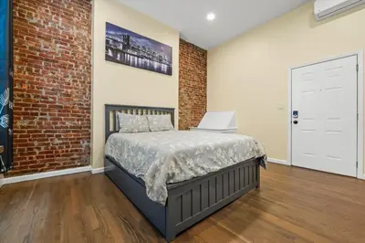 a bedroom with a bed and a brick wall at Free Parking -NEW 3BR-2Bath, 5 Beds, 10 Min to NYC, Sleeps 7 in Hoboken