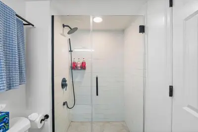 a shower with a glass door in a bathroom at Free Parking -NEW 3BR-2Bath, 5 Beds, 10 Min to NYC, Sleeps 7 in Hoboken