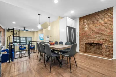 a dining room with a brick wall and a table and chairs at Free Parking -NEW 3BR-2Bath, 5 Beds, 10 Min to NYC, Sleeps 7 in Hoboken