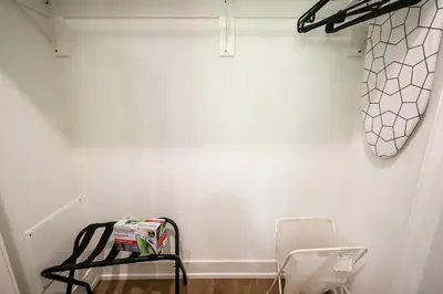 a white wall with a rack and a chair in a room at 1Bed&1Bath KingBed,WIFI,WD,Central in Philadelphia