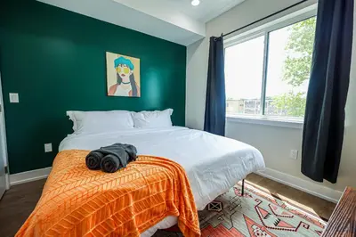 a bedroom with a bed with an orange blanket at 1Bed&1Bath KingBed,WIFI,WD,Central in Philadelphia