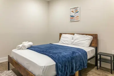 a small bedroom with a bed with a blue blanket at 4Bedrm,4Bath-BackyardWiFi WDCoffeeParking in Philadelphia