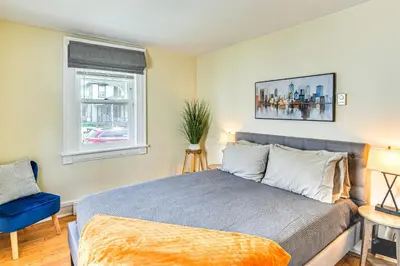 a bedroom with a bed and a blue chair and a window at Near Nockamixon State Park Telford Apt with Porch! in Telford