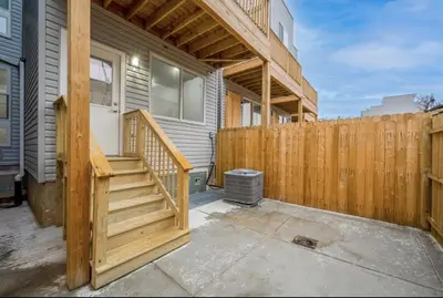 a wooden fence next to a house with a wooden staircase at 4BR4Bath Home WiFi WD Ping Pong in Philadelphia