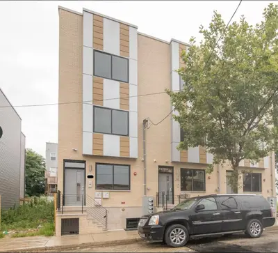 a black car parked in front of a building at 4BR4Bath Home WiFi WD Ping Pong in Philadelphia