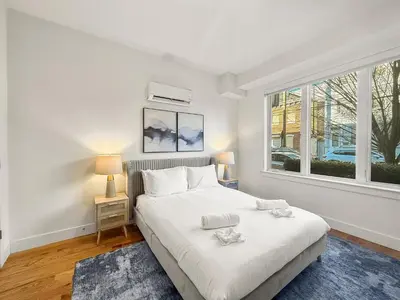 a white bedroom with a bed and a window at Apartmint at Liberty B - Philadelphia in Philadelphia