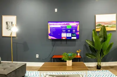a living room with a flat screen tv on a wall at 2BR2BA ApartmentWDWiFi Near Temple in Philadelphia