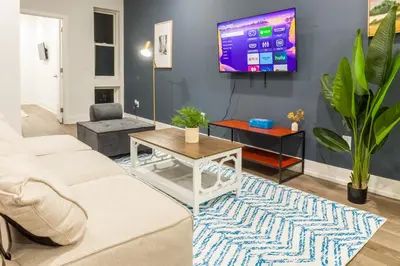 a living room with a couch and a tv on a wall at 2BR2BA ApartmentWDWiFi Near Temple in Philadelphia