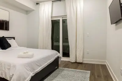 a white bedroom with a bed and a window at 2BR2BA ApartmentWDWiFi Near Temple in Philadelphia