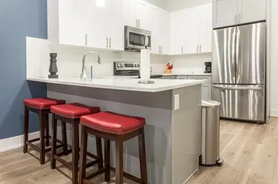 a kitchen with a counter with stools and a refrigerator at Central Philly 2BR2BAWiFi WDSleeps 4-6 in Philadelphia