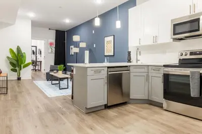 a kitchen with white cabinets and a blue wall at Central Philly 2BR2BAWiFi WDSleeps 4-6 in Philadelphia