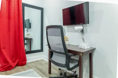 a desk with a chair and a television on a wall at Central Philly 2BR2BAWiFi WDSleeps 4-6 in Philadelphia