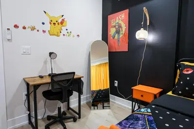 a bedroom with a desk and a bed and a table at Chill in Style Anime Themed Escape in Philadelphia