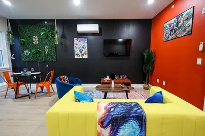 a living room with a yellow couch and a table at Chill in Style Anime Themed Escape in Philadelphia