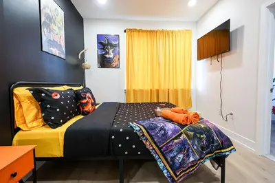 a bedroom with a bed with colorful pillows on it at Chill in Style Anime Themed Escape in Philadelphia