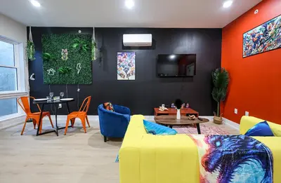 a living room with a yellow couch and a table at Chill in Style Anime Themed Escape in Philadelphia