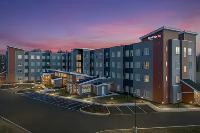 a rendering of an apartment building at dusk at Residence Inn by Marriott Newark, DE in Newark