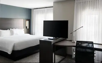 a bedroom with a bed and a desk with a television at Residence Inn by Marriott Newark, DE in Newark
