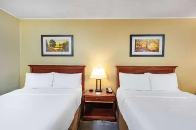 a hotel room with two beds and a table with a lamp at Wyndham Garden York in York