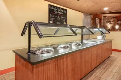a food counter in a restaurant with silver dishes at Wyndham Garden York in York