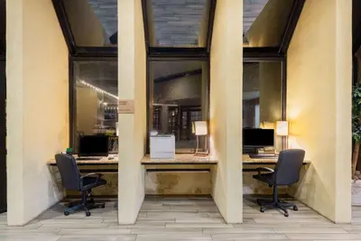 a lobby with two chairs and a desk with two computers at Wyndham Garden York in York