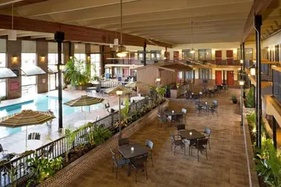 an empty cafeteria with tables and chairs and a pool at Wyndham Garden York in York