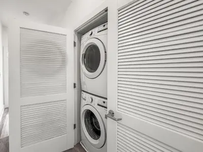 a laundry room with two washing machines and a window at Apartmint at Liberty C - Philadelphia in Philadelphia