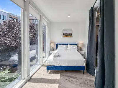 a bedroom with a bed and a large window at Apartmint at Liberty C - Philadelphia in Philadelphia