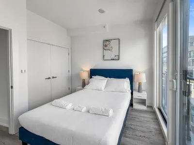 a bedroom with a large white bed with a blue headboard at Apartmint at Liberty C - Philadelphia in Philadelphia