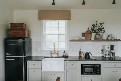 a kitchen with a black refrigerator and a sink at Luxury Cabin at Beaver Creek with Hot tub and stunning views in Strasburg