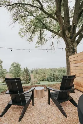 two chairs and a table under a tree at Luxury Cabin at Beaver Creek with Hot tub and stunning views in Strasburg