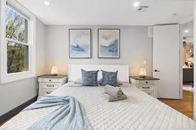a bedroom with a large white bed with blue pillows at Luxury and Chic 2BR 2BA Apt Mins to NYC and Hoboken in Jersey City