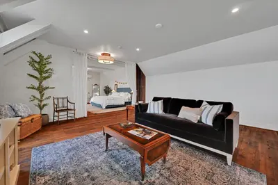 a living room with a black couch and a table at The Boat House Water Views Sunsets in York