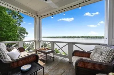 a porch with two chairs and a view of the water at The Boat House Water Views Sunsets in York