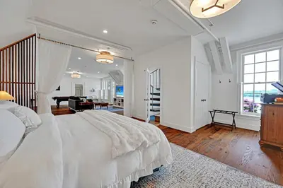a white bedroom with a bed and a piano at The Boat House Water Views Sunsets in York
