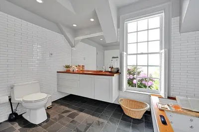 a white bathroom with a toilet and a window at The Boat House Water Views Sunsets in York