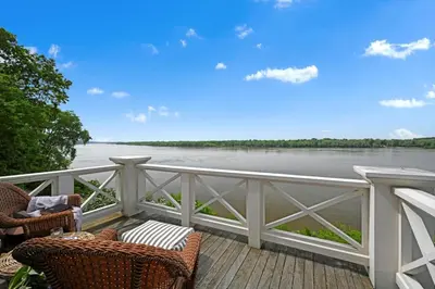 a balcony with chairs and a view of the water at The Boat House Water Views Sunsets in York