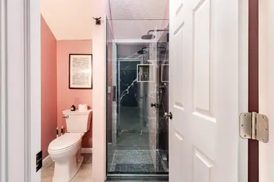 a bathroom with a toilet and a glass shower at Azure on the Pocono in Tobyhanna